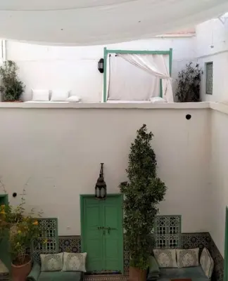 a room with a green door and a plant at Riad Charij in Marrakech