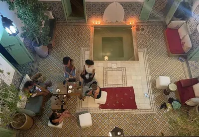 a group of people sitting around a table in a room at Riad Charij in Marrakech