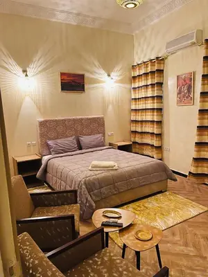 a bedroom with a bed and a couch and a table at Soleil de Medina in Marrakech