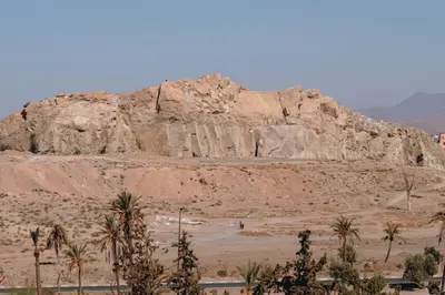 a large rock formation in the desert with palm trees at Chic 2 Bedroom with Mountain views Gueliz in Marrakech