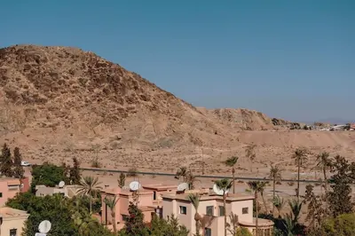 a town in front of a mountain with palm trees at Chic 2 Bedroom with Mountain views Gueliz in Marrakech