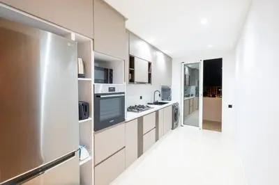 a kitchen with white cabinets and a stainless steel refrigerator at Luxury 2 Bedroom with Mountain View in Marrakech