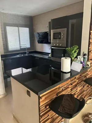 a kitchen with a black counter top and a microwave at Prestigia corail in Marrakech