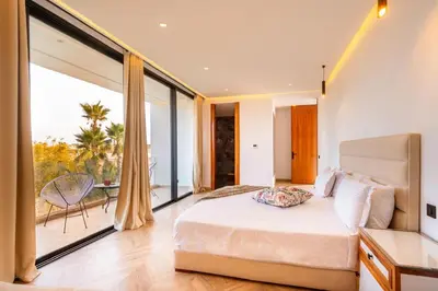 a bedroom with a large bed and a balcony at Villa Saphia K in Marrakech