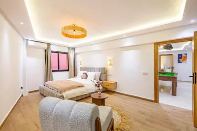 a bedroom with a bed and a couch and a mirror at Verdelune Apartments in Marrakech