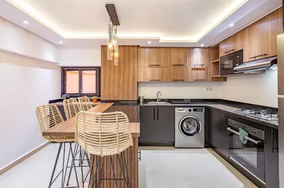a kitchen with wooden cabinets and a washer and dryer at Verdelune Apartments in Marrakech