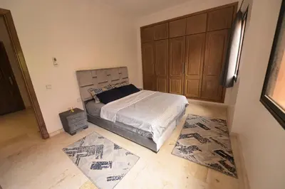 a bedroom with a bed and a wooden cabinet at Carisia Liam in Marrakech