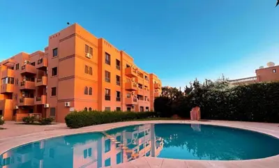 a building with a swimming pool in front of a building at Carisia Liam in Marrakech
