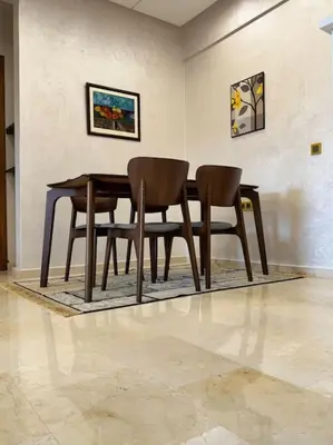 a wooden table and two chairs in a room at Appartement Sylia in Marrakech