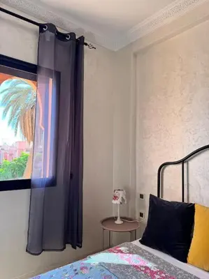 a bedroom with a bed and a painting on the wall at Appartement Sylia in Marrakech
