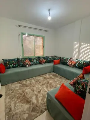 a living room with a green couch and red pillows at Apparemment in Marrakech