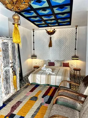 a bedroom with a bed and a blue ceiling at Riad dar darcom in Marrakech