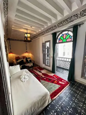 a bedroom with a bed and a stained glass window at Riad dar darcom in Marrakech