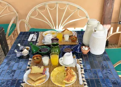 a table with breakfast foods and drinks on it at Riad dar darcom in Marrakech