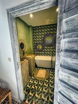 a bathroom with a tub and a toilet and a tub at Riad dar darcom in Marrakech