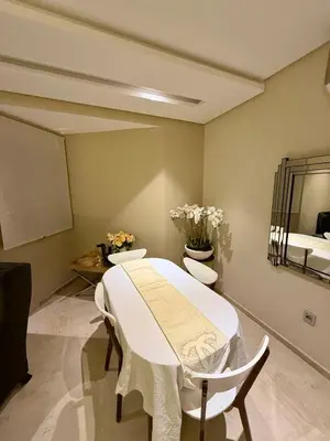 a room with a table and two chairs and a bed at Prestigia Marrakech golf city appartement 3 chambre in Marrakech