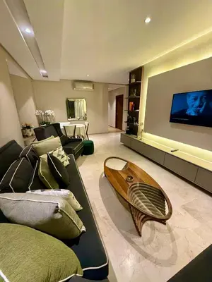 a living room with a couch and a surfboard on the floor at Prestigia Marrakech golf city appartement 3 chambre in Marrakech