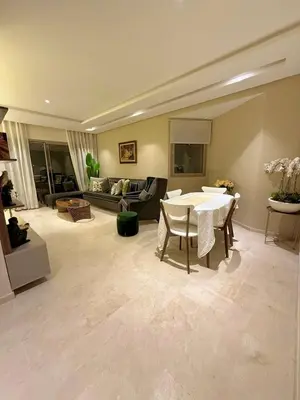 a living room with a table and a couch at Prestigia Marrakech golf city appartement 3 chambre in Marrakech