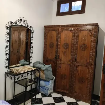 a room with a large wooden wardrobe and a mirror at Appartement T3 Le petit chat in Marrakech
