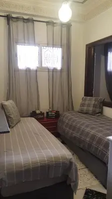 a bedroom with two beds and a window at Appartement T3 Le petit chat in Marrakech