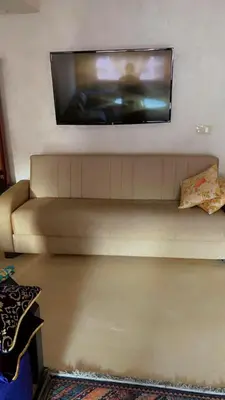 a flat screen tv on a wall above a couch at HOURIA LOC Marrakech in Marrakech