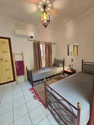 a bedroom with two beds and a chandelier at Mira Medina Garden in Marrakech