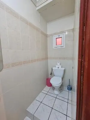 a white bathroom with a toilet and a window at Mira Medina Garden in Marrakech