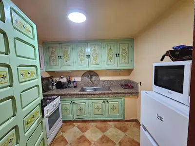 a kitchen with green cabinets and a sink and a microwave at Mira Medina Garden in Marrakech