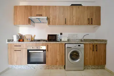 a kitchen with a washing machine and wooden cabinets at apart in the centre of marrakech gueliz in Marrakech