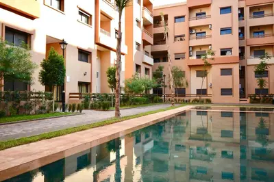 an apartment complex with a swimming pool in front of a building at apart in the centre of marrakech gueliz in Marrakech