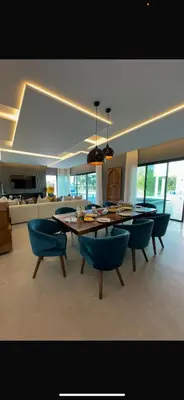 a living room with a dining room table and chairs at Magnifique villa sur front de golf Amelkis in Marrakech