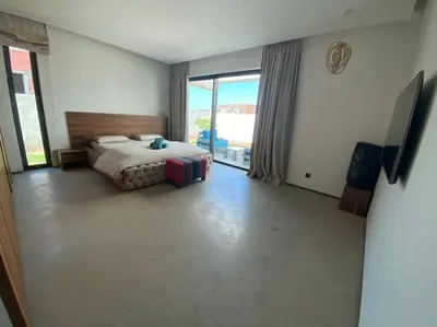 a bedroom with a bed and a large window at Magnifique villa sur front de golf Amelkis in Marrakech