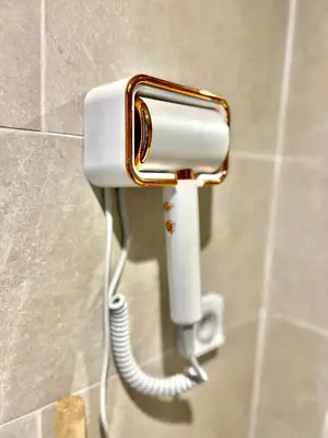 a white and gold phone on a wall in a bathroom at Noria cosy & chic jardin privé in Marrakech