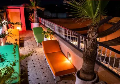 a balcony with a bench and a palm tree at Riad Romance in Marrakech