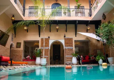 a house with a swimming pool in front of a building at Riad Romance in Marrakech