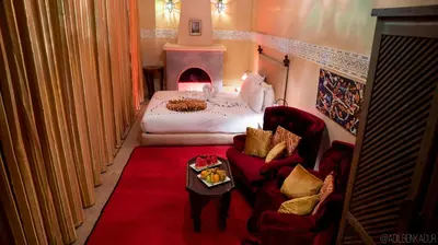 a room with a bed and a red carpet at Riad Romance in Marrakech