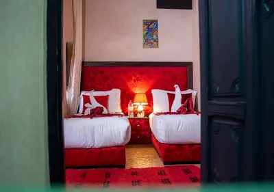 a bedroom with two beds and a red headboard at Riad Romance in Marrakech