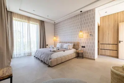 a bedroom with a large bed and a large window at Villa 150 Amelkis 2-piscine chauffée in Marrakech
