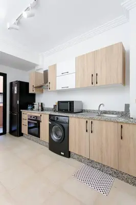 a kitchen with a washer and a sink and a dishwasher at Feel At Home Heart Of Marrakech in Marrakech
