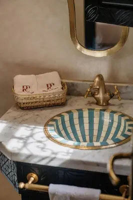 a bathroom counter with a sink and a mirror at Riad Cologne in Marrakech