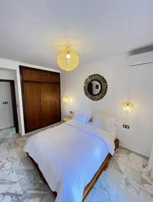 a bedroom with a large white bed and a mirror at Dreamy Majorelle and Bohemian Majorelle in Marrakech