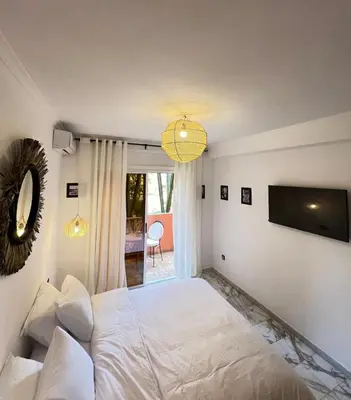 a bedroom with a white bed and a television at Dreamy Majorelle and Bohemian Majorelle in Marrakech