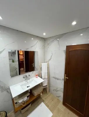a bathroom with a sink and a marble wall at Dreamy Majorelle and Bohemian Majorelle in Marrakech