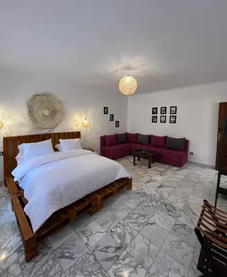 a bedroom with a large bed and a red couch at Dreamy Majorelle and Bohemian Majorelle in Marrakech