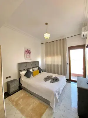 a bedroom with a bed and a chandelier at Full Moon APPARTS in Marrakech
