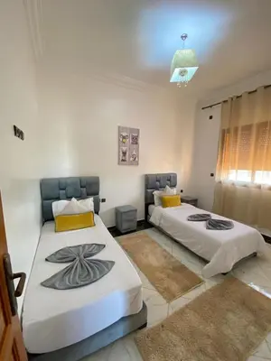 two beds sitting in a room with at Full Moon APPARTS in Marrakech