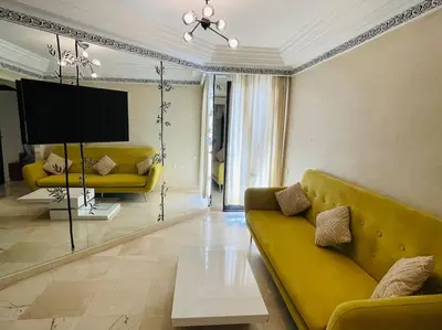 a living room with a yellow couch and a tv at Confort et Style Studio Chic avec Piscine in Marrakech