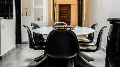 a dining room with a table and black chairs at Riad SASHA Exclusive&New Pool 6 pax Free Breakfast in Marrakech