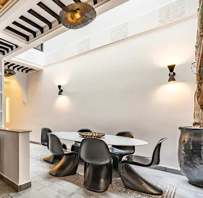 a dining room with a table and black chairs at Riad SASHA Exclusive&New Pool 6 pax Free Breakfast in Marrakech