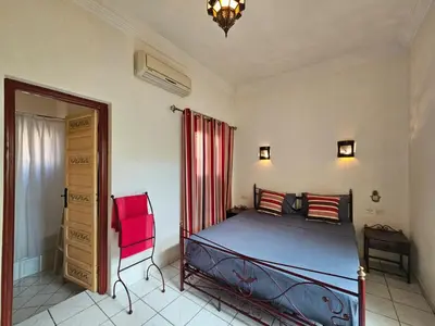 a bedroom with a bed and a red curtain at Riad Oued Issil in Marrakech
